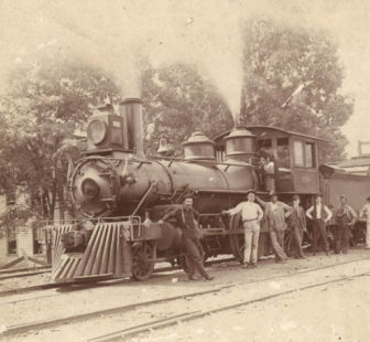 Group standing in front train, probably part of the Southern Railway